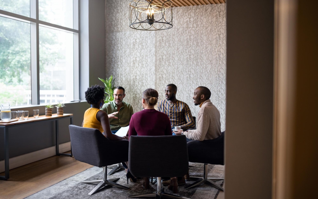 Group of people talking at a round table in office