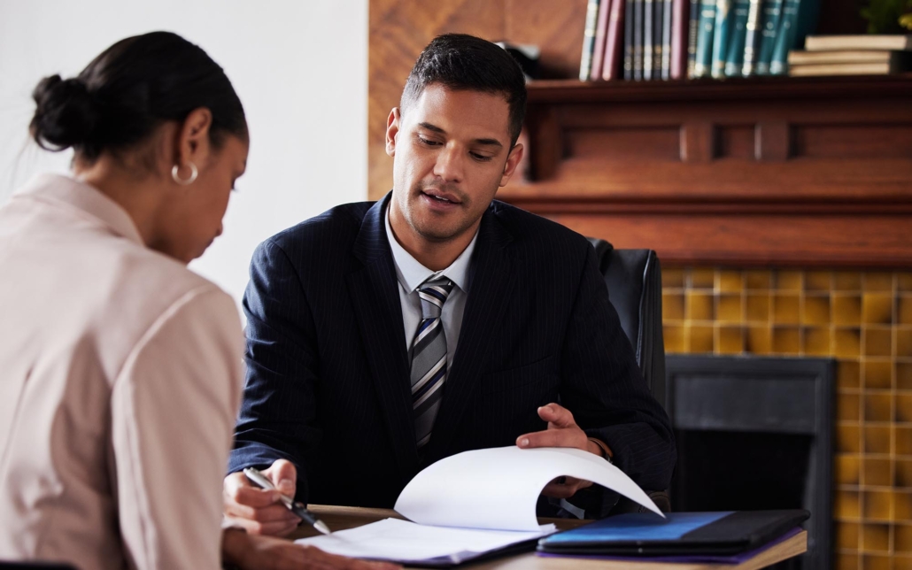 Person showing another person various notes on clipboard in office