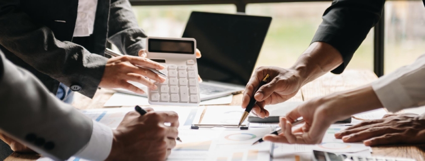 A group of people around a desk looking at financial documents