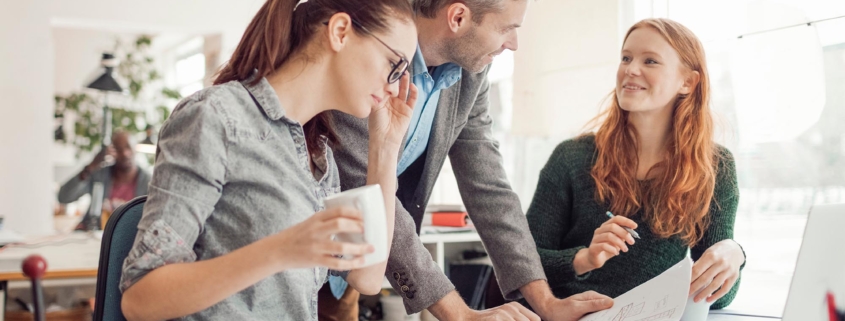 Three professionals working together on some documents