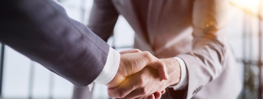 Side view of two people shaking hands