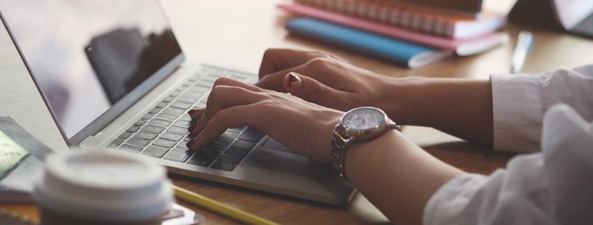 Side view of a woman using a laptop