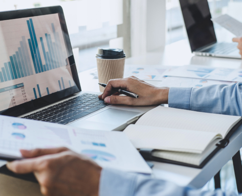 Man in front of computer using laptop for finance