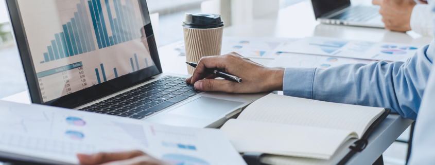 Man in front of computer using laptop for finance