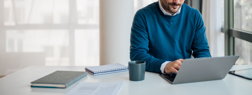Front view of young professional doing financial work on computer, small business