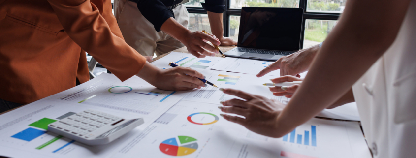 Side view of financial team analyzing charts and graphs