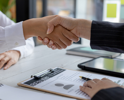 Side view of two financial experts shaking hands