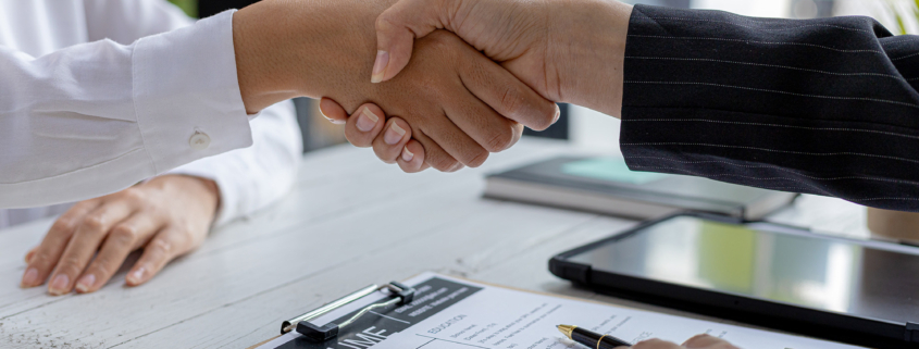 Side view of two financial experts shaking hands