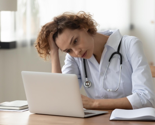 Medical professional at computer stressed out