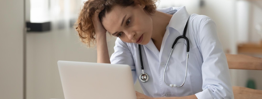 Medical professional at computer stressed out