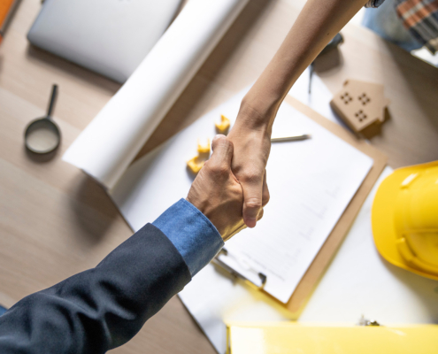 Owner of home shaking hands after architect build home finish