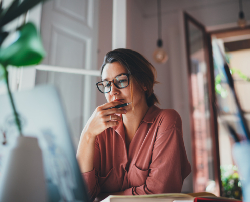 businesswoman thinking about something while sitting front open portable laptop